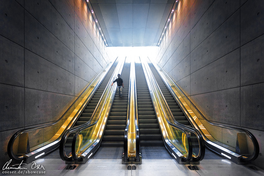 Mann auf einer Rolltreppe in der modernen Station Triangeln in Malmö, Schweden.