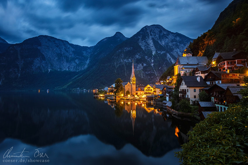 Beleuchtete Ortsansicht von Hallstatt am Hallstätter See, umgeben von Bergen, Österreich.